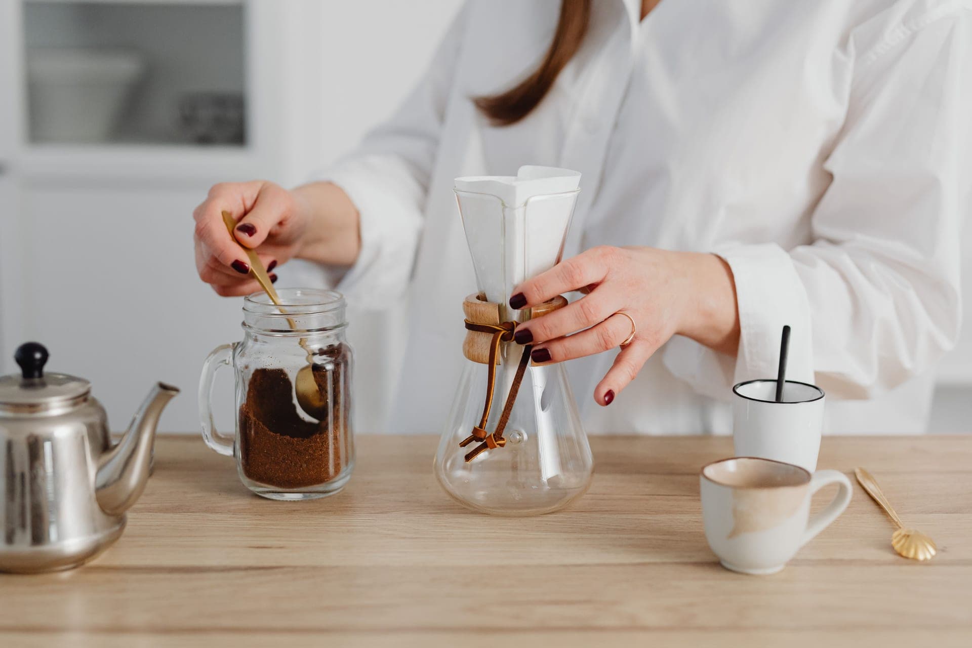 A glass pour-over brewer beside a cone dripper