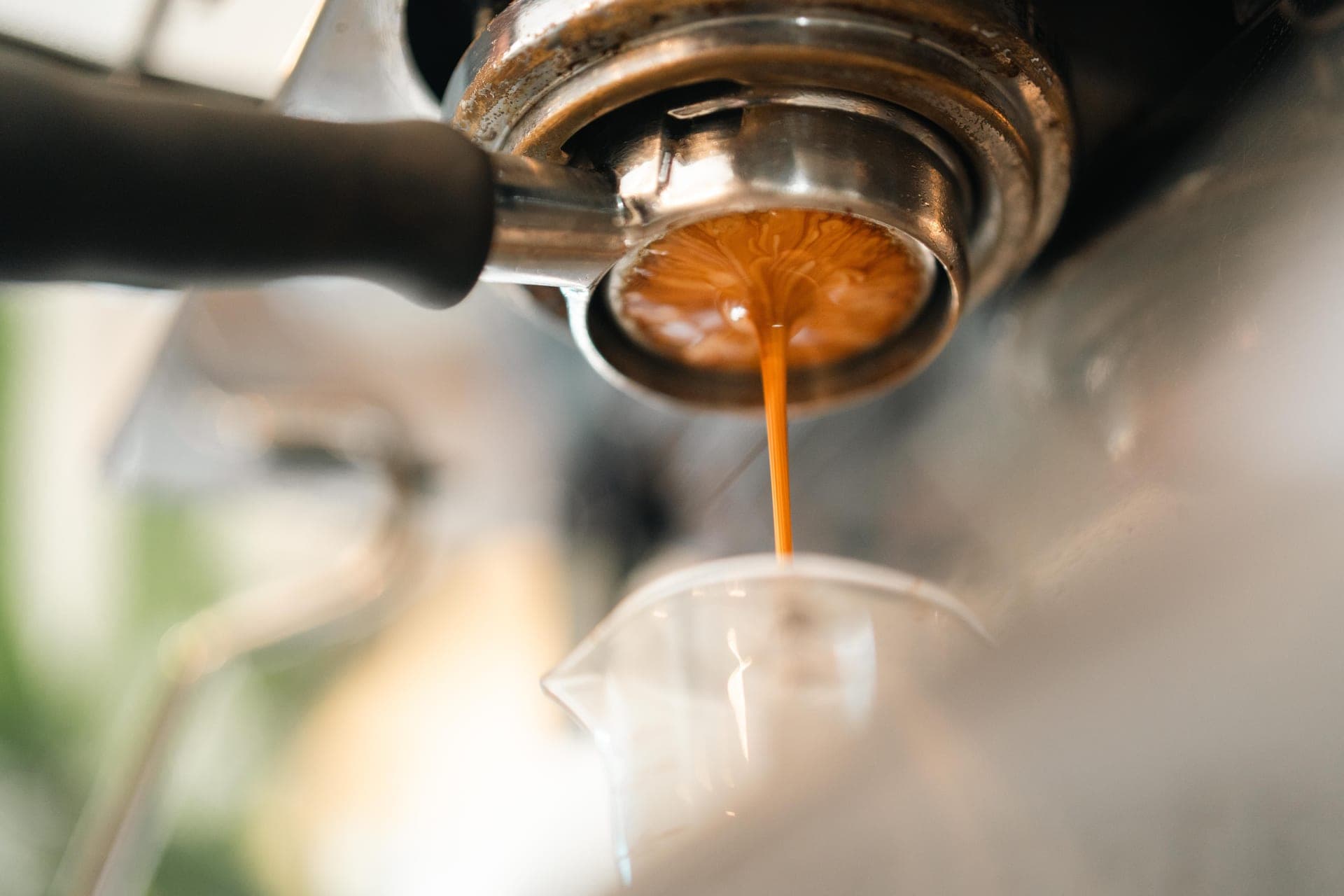 Espresso pouring from a bottomless portafilter into a cup