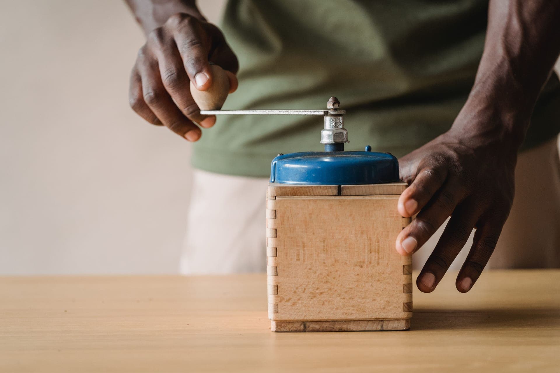 A manual hand coffee grinder on a wooden table