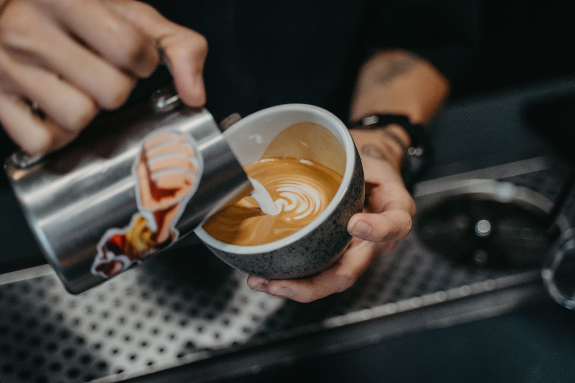 Milk being poured into a cup of espresso