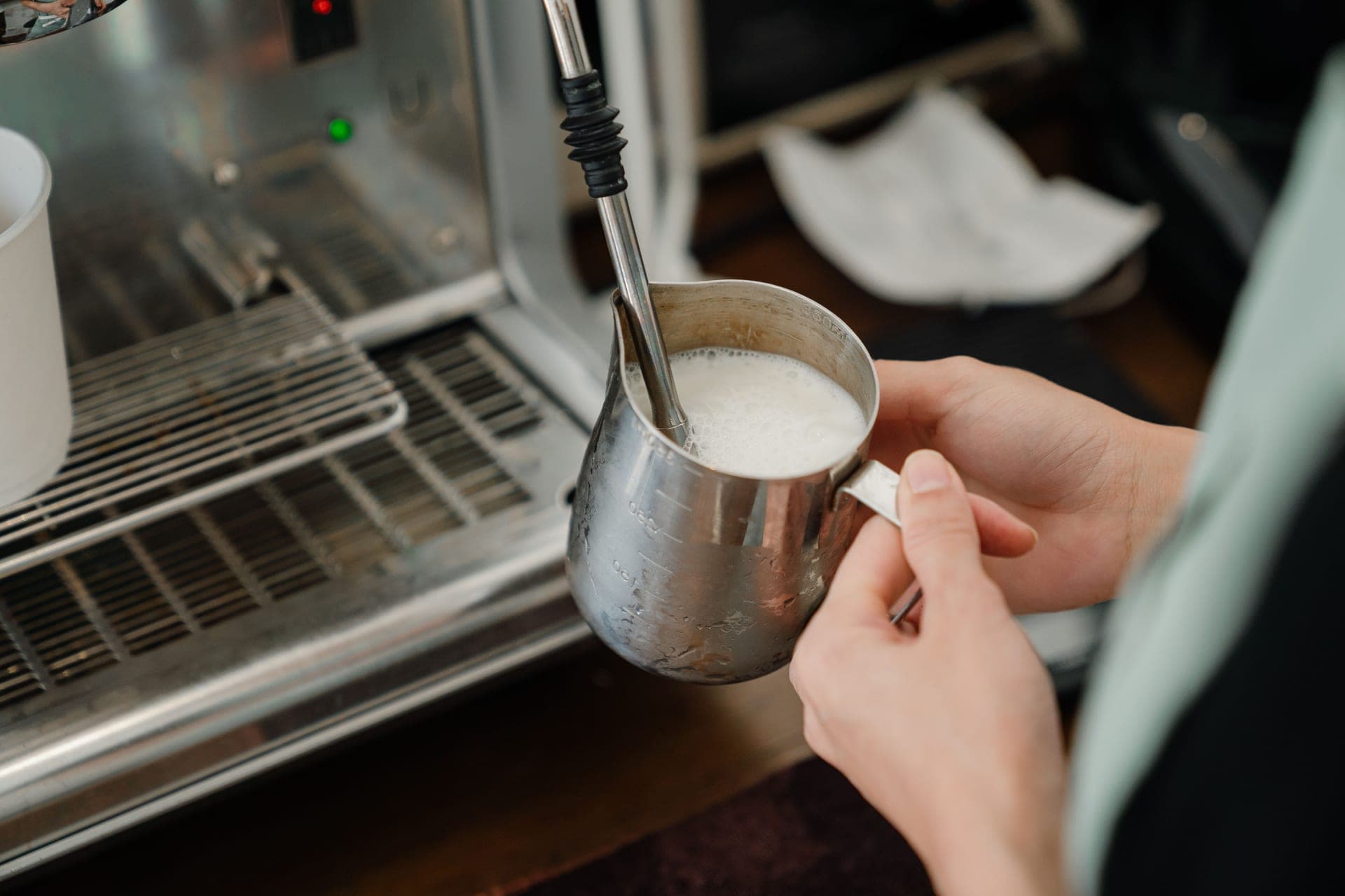 Steamed milk being poured into a cup